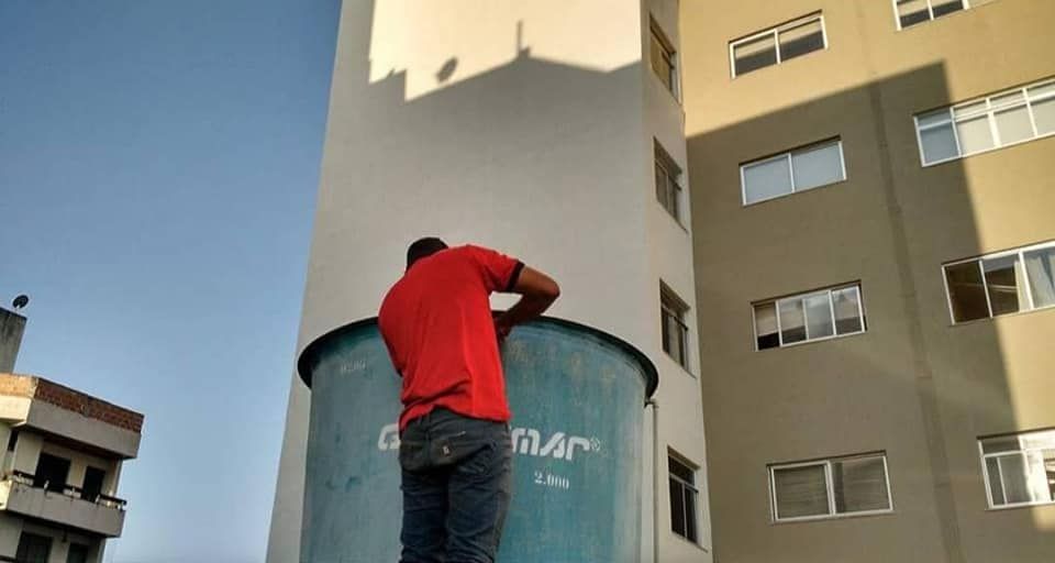 Profissional realizando higienização de reservatório de água